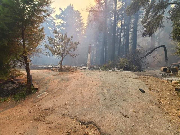 Part of a chimney (center) is all that remains of the home of a church family from Boulder Creek United Methodist Church in Boulder Creek, Calif. The family, a young couple with two children, are safe, sheltering in Santa Cruz, Calif., but their possessions are a total loss. Photo courtesy of the Rev. Clyde Vaughn, Boulder Creek United Methodist Church.