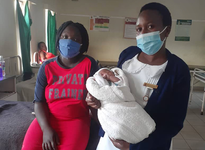 Angela Macherechedze, sister-in-charge of the family and child health unit at United Methodist Old Mutare Mission Hospital in Zimbabwe, holds baby Prince Anotidaishe, the first child for 18-year-old Samantha Sibanda, who traveled more than 160 miles to give birth at the church hospital. Photo by Kudzai Chingwe, UM News.