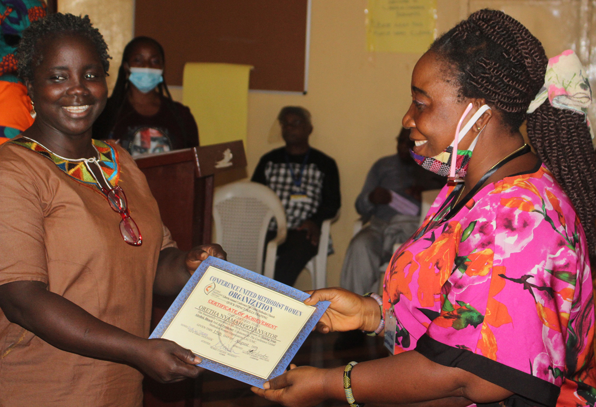 Oretha Goyanvator receives a certificate during training led by United Methodist Women in Monrovia, Liberia. As part of the new Village Saving Scheme program, participants learned to make soap, detergent and sanitary pads to help them earn and save money during the COVID-19 pandemic. Photo by E Julu Swen, UM News. 