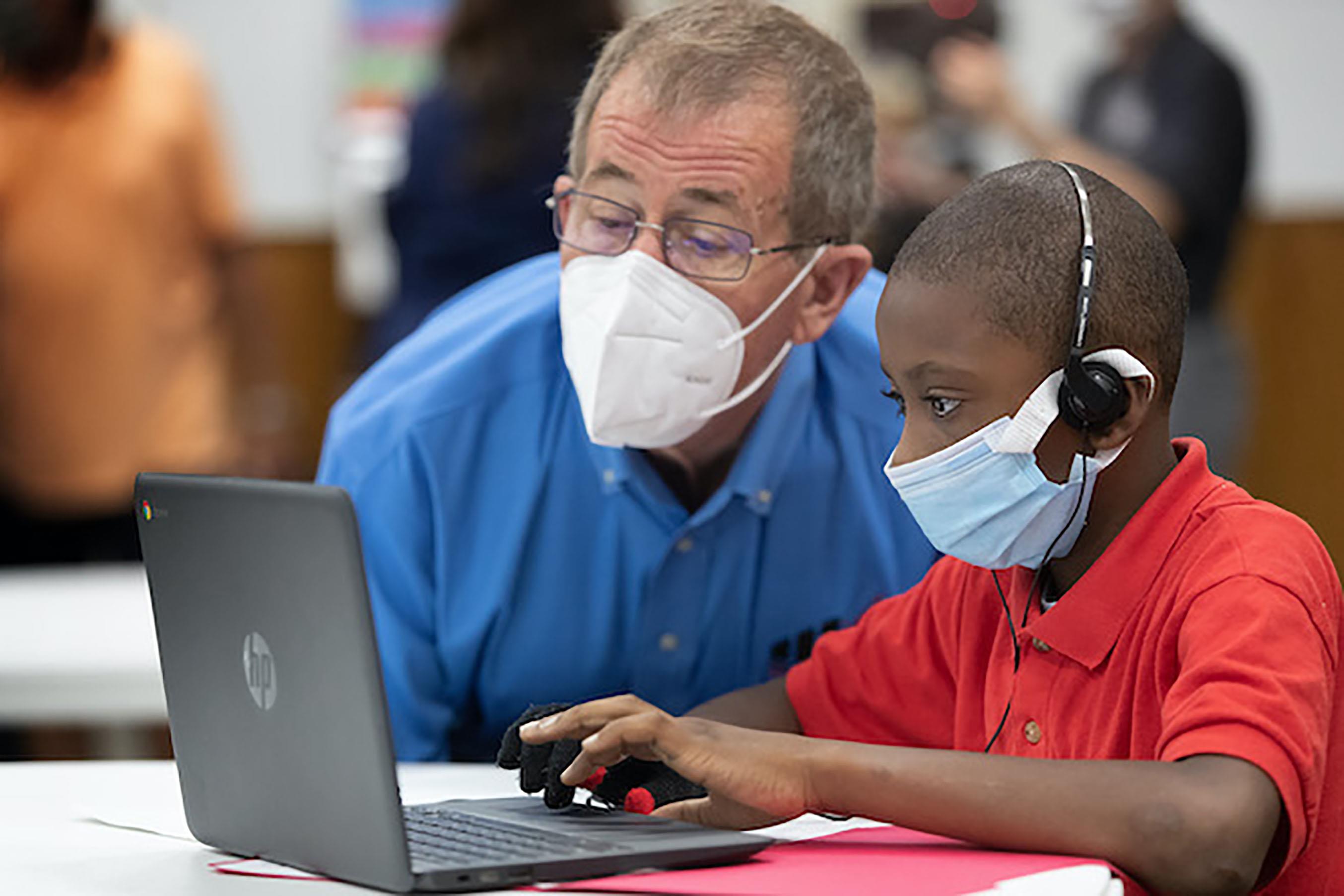 Bispo Scott Jones visita o aluno da 3ª série, Dondren Wilson, no primeiro dia do programa Santuários de Aprendizagem na Igreja Metodista Unida Trinity em Houston. O programa, iniciado pela Conferência do Texas da Igreja Metodista Unida, oferece um espaço seguro, acesso à Internet e outros recursos nas igrejas da área, permitindo que os pais retornem ao trabalho e seus filhos continuem seus estudos durante a pandemia COVID-19. Foto de Mike DuBose, Notícias MU.
