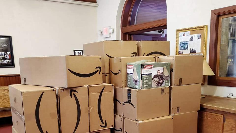 Pilhas de caixas com sacos de dormir doados para os desabrigados ocupam espaço no andar de baixo da Igreja Aspen Community. Foto de cortesia Aspen Community United Methodist Church. 