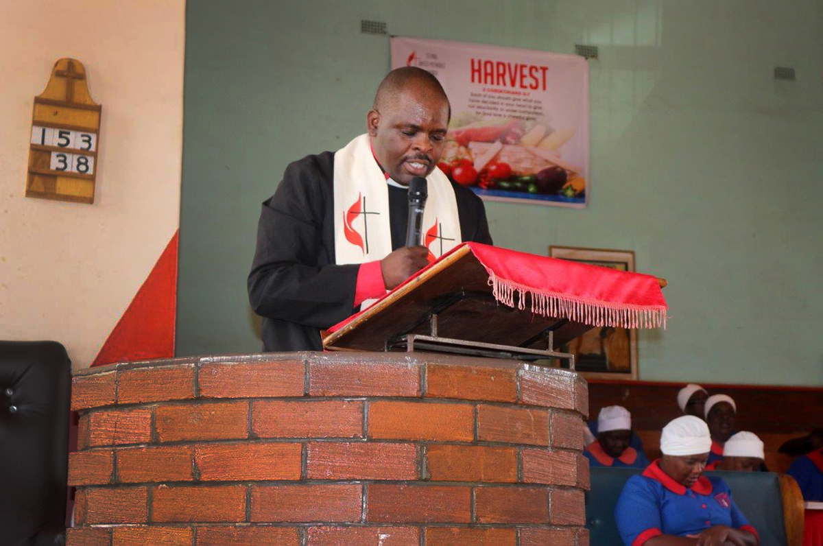 The Rev. Moore Ganda, senior pastor, prays for the congregation at St. Paul United Methodist Church in Harare, Zimbabwe. Due to COVID-19 and the country’s economic crisis, the congregation is being asked to help augment clergy salaries. Photo by Priscilla Muzerengwa, UM News. 