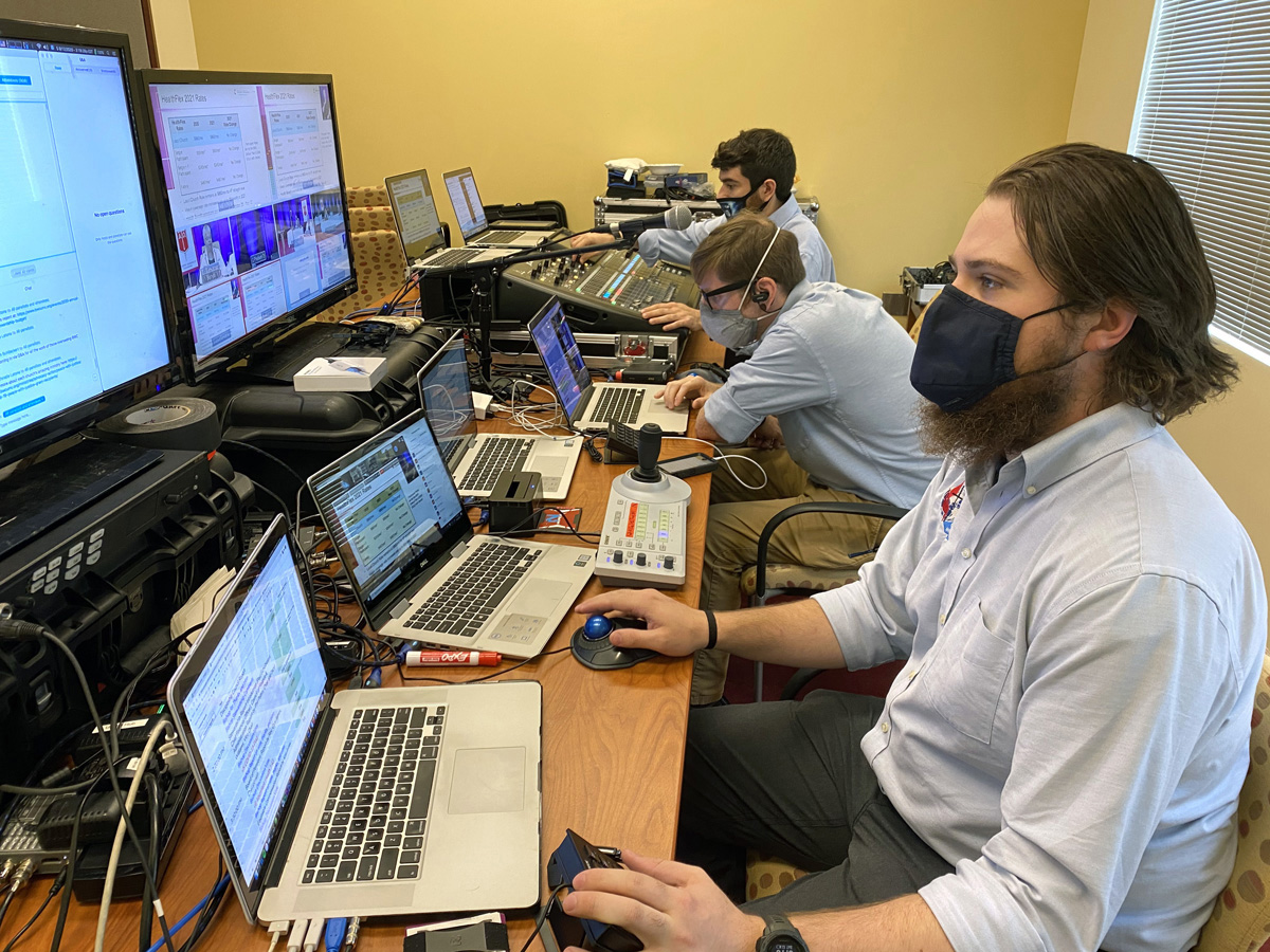 Uma visão da sala de controle de vídeo do GNTV Media Ministry durante a reunião anual da Conferência Baltimore-Washington mostra várias telas de computador, equipamento de áudio e técnicos ocupados. Foto cortesia do GNTV Media Ministry. Uma visão da sala de controle de vídeo do GNTV Media Ministry durante a reunião anual da Conferência Baltimore-Washington mostra várias telas de computador, equipamento de áudio e técnicos ocupados. Foto cortesia do GNTV Media Ministry.