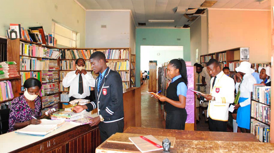 Rachel Barwe issues textbooks to students in the library at Hartzell High School, a United Methodist school at Old Mutare Mission in Mutare, Zimbabwe. A 2019 fire burned many of the school’s textbooks, creating challenges for students and staff. Photo by Kudzai Chingwe, UM News. 
