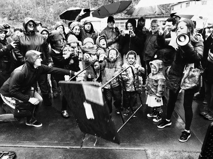 Children of Valley & Mountain, a United Methodist church in Seattle, turn over tables in front of the local headquarters of U.S. Immigration and Customs Enforcement. The protest refers to Jesus Christ turning over the tables in the temple. Photo courtesy of the Rev. John Helmiere.