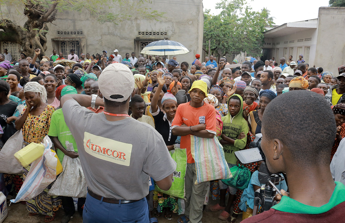 Jean Tshomba, coordinator of UMCOR's disaster management office in eastern Congo, speaks to the crowd before helping to distribute food and other items to more than 500 survivors of flooding in Uvira, Congo. Photo by Philippe Kituka Lolonga, UM News. Jean Tshomba, coordinator of UMCOR's disaster management office in eastern Congo, speaks to the crowd before helping to distribute food and other items to more than 500 survivors of flooding in Uvira, Congo. Photo by Philippe Kituka Lolonga, UM News.