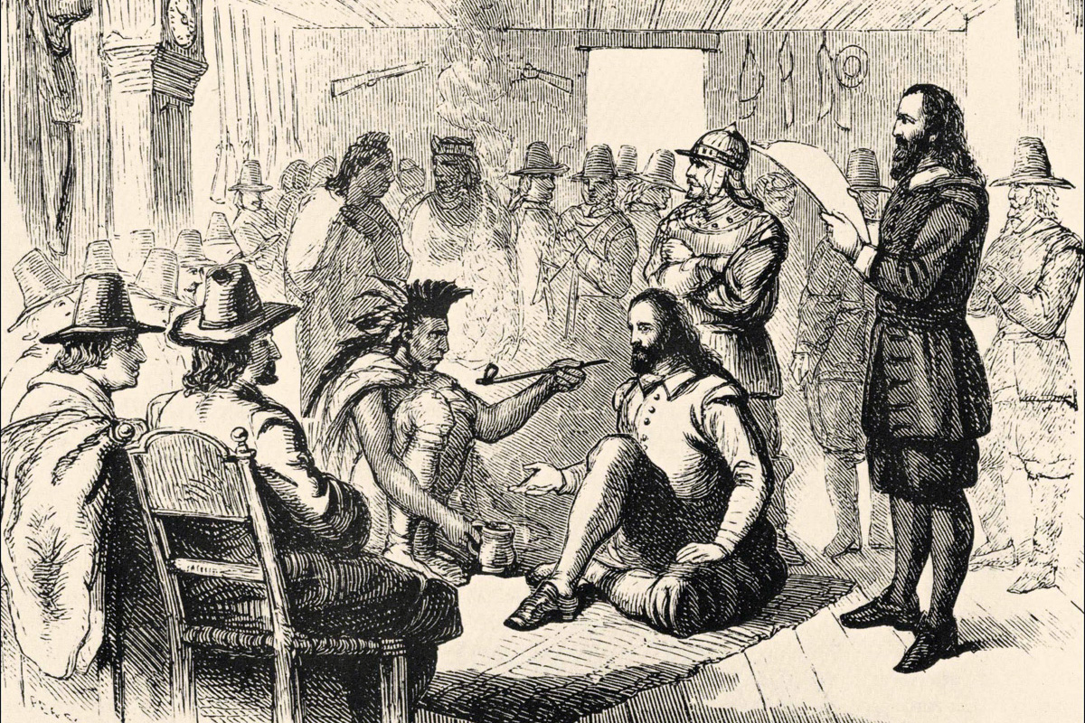 El líder de Wampanoag, Ousamequin (izquierda) y el gobernador de la colonia de Plymouth, John Carver, están representados fumando una pipa de la paz mientras elaboraban un tratado de paz y protección mutua el 22 de marzo de 1621. La tradición del Día de Acción de Gracias de EE. UU. ha mitificado la relación entre los Wampanoag y los/as colonos ingleses/as, pero las realidades más duras brindan lecciones vitales para los/as metodistas unidos/as de hoy. Imagen de la Biblioteca Estatal Sutro de California. Imagen cortesía de Wikimedia Commons.