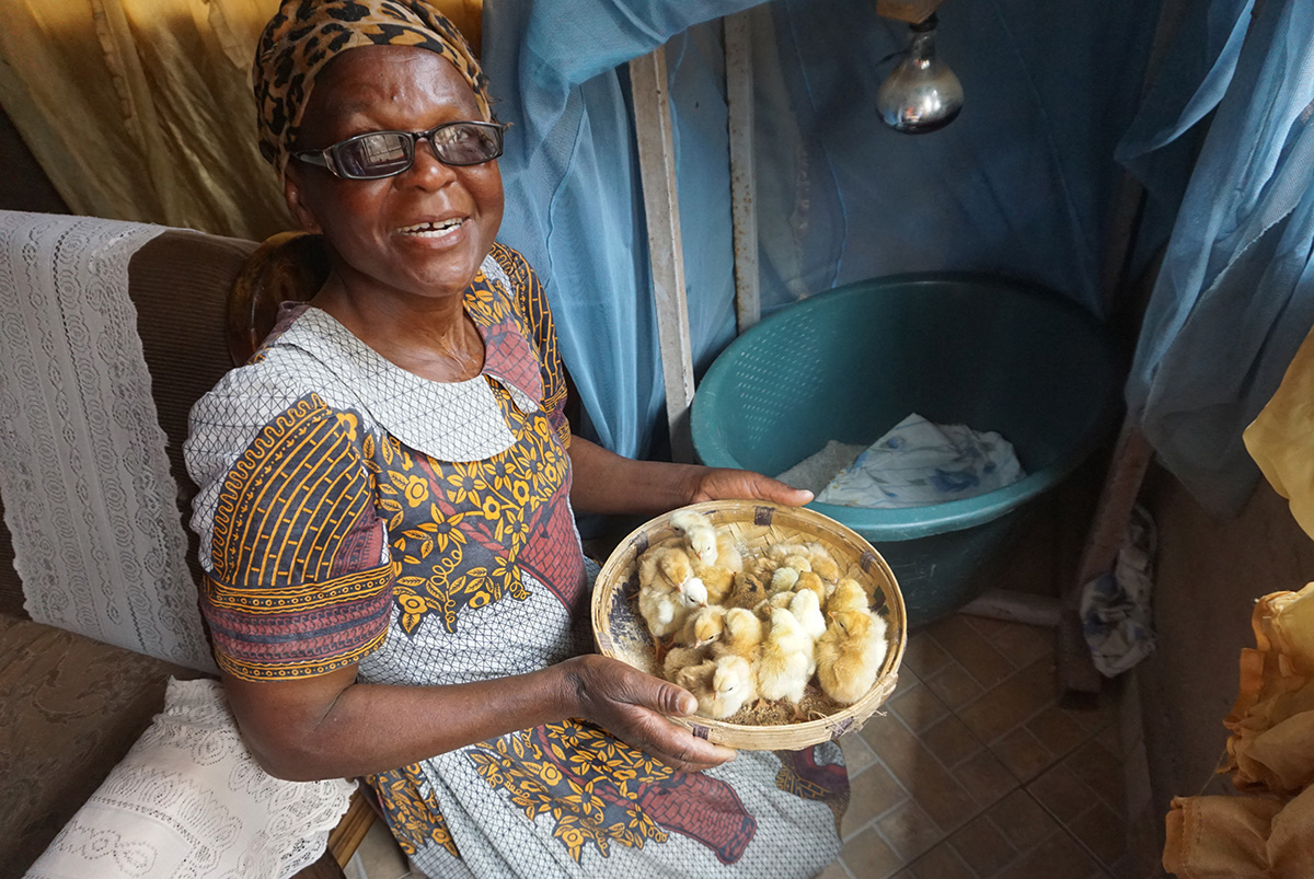 Nyengeterai Mafongoya holds a basket of 20-day-old chicks in Masvingo, Zimbabwe. She started with 20 chicks as part of a United Methodist Women poultry project in February and grown her brood to 100 birds.  Photo by Kudzai Chingwe, UM News. 
