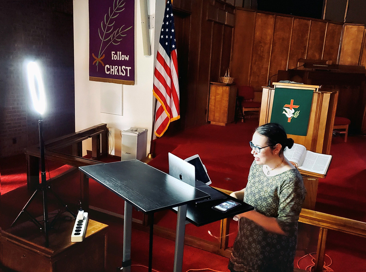 The Rev. Amy Wilson Feltz, pastor of St. Paul’s United Methodist Church in El Paso, Texas, sets up computer equipment to stream a live sermon in the church’s sanctuary in September. Although the pulpit, which is visible on-camera, has the appropriate liturgical color, the banner on the wall was from Lent, when the church had to suspend in-person worship. Photo courtesy of the Rev. Amy Wilson Feltz. The Rev. Amy Wilson Feltz, pastor of St. Paul’s United Methodist Church in El Paso, Texas, sets up computer equipment to stream a live sermon in the church’s sanctuary in September. Although the pulpit, which is visible on-camera, has the appropriate liturgical color, the banner on the wall was from Lent, when the church had to suspend in-person worship. Photo courtesy of the Rev. Amy Wilson Feltz.