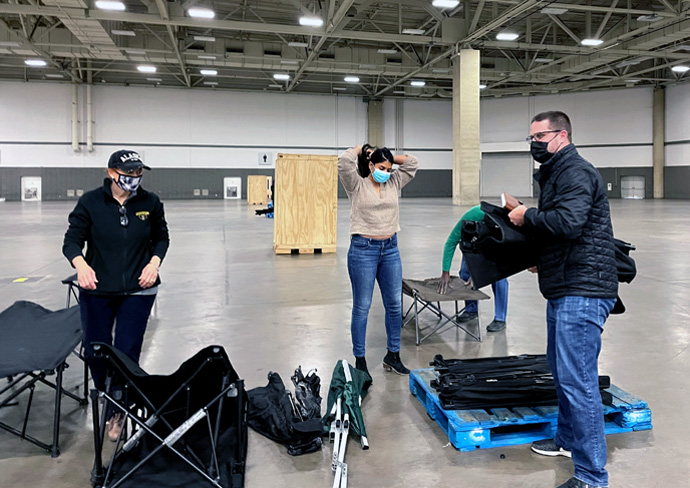 Volunteers set up cots at Dallas' Kay Bailey Hutchison Convention Center, part of a collaborative effort to provide a warm refuge for unsheltered persons as Texas deals with historic low temperatures. Oak Lawn United Methodist Church of Dallas has had a leadership role in the emergency response, which has had funding help from the North Texas Conference and individual United Methodist churches. Photo courtesy of the Rev. Rachel Baughman.