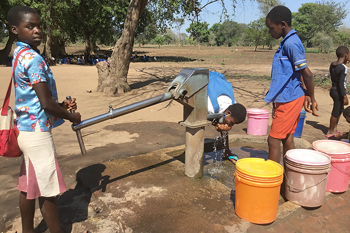 Schoolchildren drink from a borehole at Kalumba Primary School in Mangochi, Malawi, in September 2020. The borehole was drilled by the Malawi government. In response to water scarcity in this east African country, United Methodist Church of the Resurrection in Leawood, Kan., has helped fund the drilling of more than 80 boreholes since September. Photo by Francis Nkhoma, UM News.