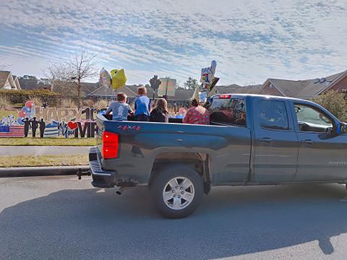 Autos y camiones llenos de familiares y amigos/as para celebrar el centésimo cumpleaños de Winston Best. Foto cortesía de WRAL.com.
