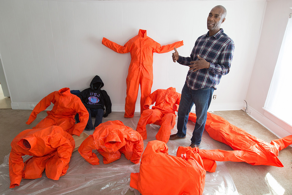 Ndume Olatushani descreve sua obra de arte de instalação com figuras humanas em macacões e moletons usados na prisão em sua casa em Nashville, Tennessee, em 2017. A obra fazia parte de uma exposição Estações da Cruz realizada em Washington, DC. Olatushani foi libertado após cumprir 27 anos de prisão, 20 deles no corredor da morte. Uma série de webinars de 26 a 30 de abril oferecerá conselhos aos membros da igreja sobre como apoiar ex-presidiários e ajudá-los a encontrar um emprego lucrativo. Foto de arquivo por Mike DuBose, Notícias MU. Ndume Olatushani descreve sua obra de arte de instalação com figuras humanas em macacões e moletons usados na prisão em sua casa em Nashville, Tennessee, em 2017. A obra fazia parte de uma exposição Estações da Cruz realizada em Washington, DC. Olatushani foi libertado após cumprir 27 anos de prisão, 20 deles no corredor da morte. Uma série de webinars de 26 a 30 de abril oferecerá conselhos aos membros da igreja sobre como apoiar ex-presidiários e ajudá-los a encontrar um emprego lucrativo. Foto de arquivo por Mike DuBose, Notícias MU.