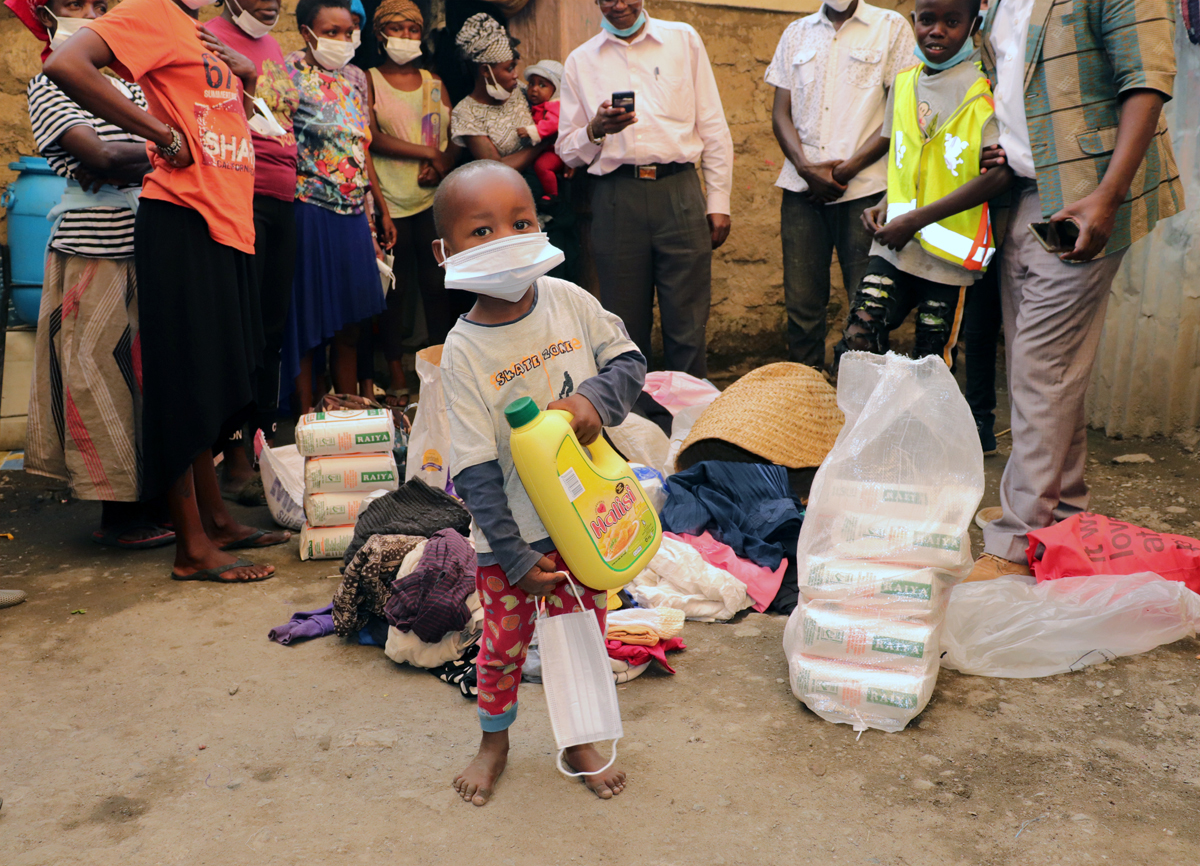 Maina, a 4-year-old who was abandoned, carries cooking oil and a mask received from the Homeless Compassion Ministry, an initiative of the Nairobi District of The United Methodist Church. The COVID-19 pandemic has created additional challenges for women and children living on the streets in Nairobi, Kenya. Photo by Gad Maiga, UM News. Maina, a 4-year-old who was abandoned, carries cooking oil and a mask received from the Homeless Compassion Ministry, an initiative of the Nairobi District of The United Methodist Church. The COVID-19 pandemic has created additional challenges for women and children living on the streets in Nairobi, Kenya. Photo by Gad Maiga, UM News.