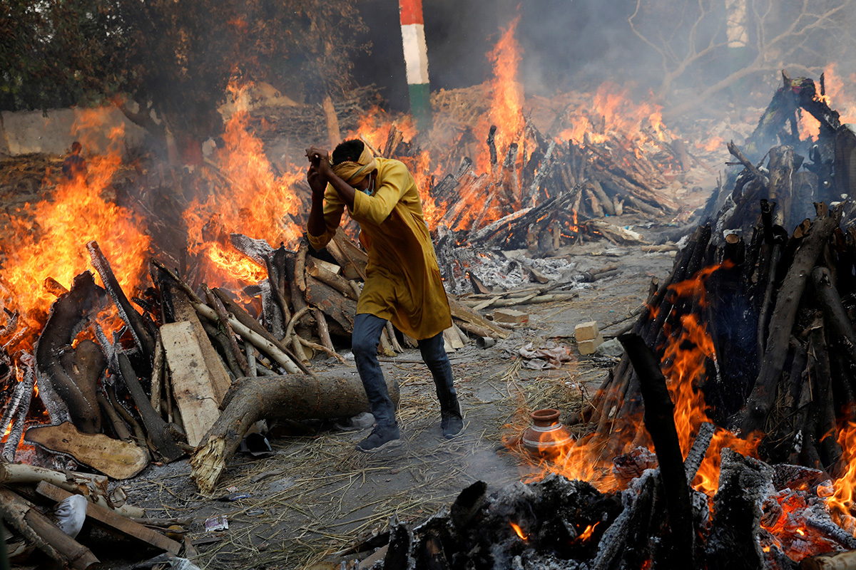 Un hombre pasa corriendo junto a las piras funerarias en llamas de personas que murieron a causa del COVID-19, durante una cremación masiva en un crematorio en Nueva Delhi, India. La creciente crisis en la India será abordada por La Iglesia Metodista Unida (IMU) a través de subvenciones a entidades que han sido sus socias en el pasado. Foto de Adnan Abidi, Reuters. Un hombre pasa corriendo junto a las piras funerarias en llamas de personas que murieron a causa del COVID-19, durante una cremación masiva en un crematorio en Nueva Delhi, India. La creciente crisis en la India será abordada por La Iglesia Metodista Unida (IMU) a través de subvenciones a entidades que han sido sus socias en el pasado. Foto de Adnan Abidi, Reuters.