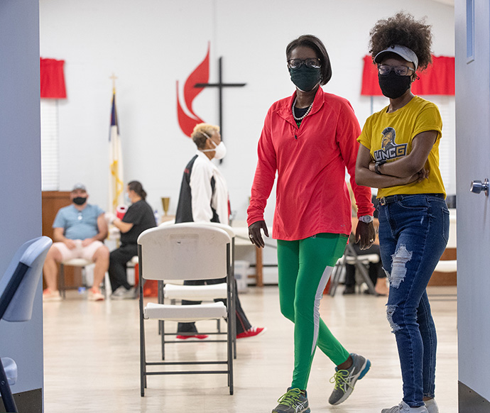 The Rev. Dr. Stephanie Moore Hand (left) and her daughter Ashlee Hand monitor the line of people waiting to receive a COVID-19 vaccination at St. Mark’s United Methodist Church in Charlotte, N.C. Photo by Mike DuBose, UM News.