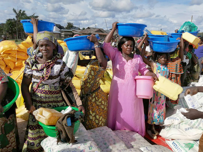 Displaced women carry food and other supplies they received from the United Methodist Committee on Relief in Beni, Congo. More than 850 vulnerable households benefitted from the outreach. Photo by Philippe Kituka Lolonga, UM News.