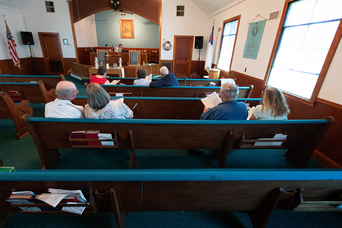 A congregation of seven sings during worship at Oakton United Methodist Church outside Clinton, Ky. Pastor Laura Vincent plays the piano behind the altar. Small, rural churches struggled through the coronavirus pandemic, but many of them are now enjoying the return to in-person services and looking to the future.  A congregation of seven sings during worship at Oakton United Methodist Church outside Clinton, Ky. Pastor Laura Vincent plays the piano behind the altar. Small, rural churches struggled through the coronavirus pandemic, but many of them are now enjoying the return to in-person services and looking to the future.