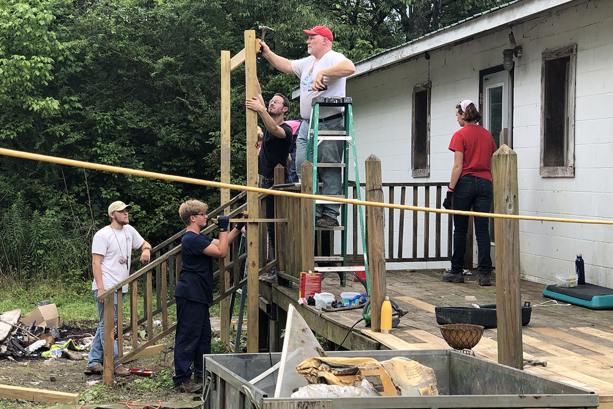 Youth and adults from Oregon United Methodist Church and St. Mary’s Catholic Church, both in Oregon, Ill., repair the porch on a home in Tracy City, Tenn. The team volunteered with Mountain T.O.P., a ministry that serves families in the Cumberland Mountain region of southeast Tennessee. Photo by the Rev. Thomas Kim, UM News.