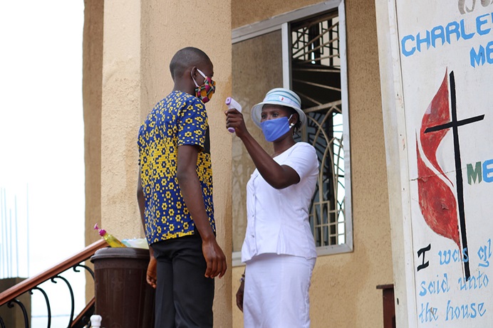 A worshipper's temperature is taken before he is allowed into the worship service July 19, 2020, at Charles Davies United Methodist Church in western Freetown, Sierra Leone. On Aug. 16, a ban on congregational worship was lifted in the country, but churches must adhere to guidelines, including the use of face masks, social distancing and limiting services to 90 minutes. File photo by Phileas Jusu, UM News. A worshipper's temperature is taken before he is allowed into the worship service July 19, 2020, at Charles Davies United Methodist Church in western Freetown, Sierra Leone. On Aug. 16, a ban on congregational worship was lifted in the country, but churches must adhere to guidelines, including the use of face masks, social distancing and limiting services to 90 minutes. File photo by Phileas Jusu, UM News.