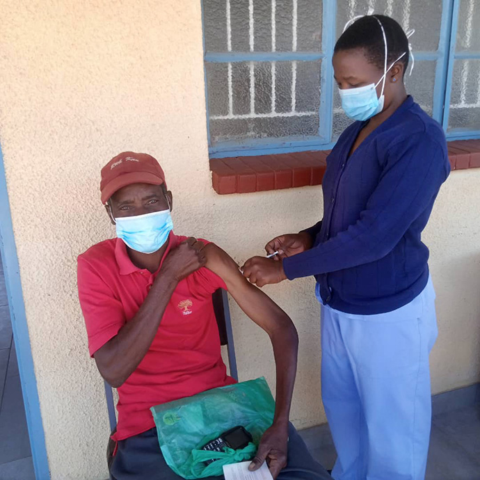 Pharaoh Mukototsi receives a COVID-19 vaccination from nurse Belinda Mashoko at The United Methodist Church’s Dindi Clinic in Zimbabwe. File photo by Kudzai Chingwe, UM News.