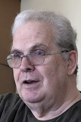 The Rev. Bill Jenkins speaks about the impact his son Harry has had.  “He taught me how to laugh again. … When this little boy arrived to my house, he just filled it with his laugh,” Jenkins said. “All the immigrants, if you allow them, will teach you to laugh.” Still frame from video by Joey Butler, UM News.