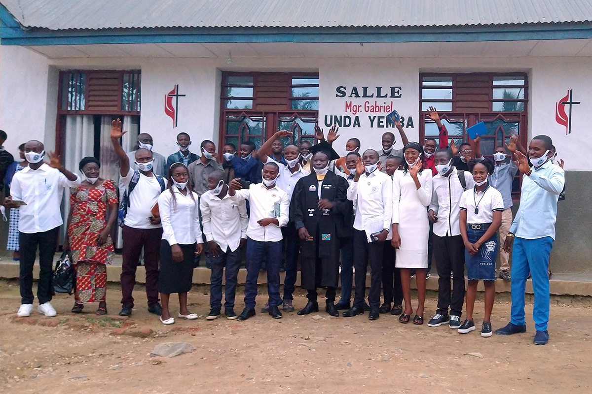 Pastor Raphaël Makanga Mikuwa (center) stands with youth and leaders of the East Congo Conference at the Bishop Gabriel Yemba Unda Center in Kindu, Congo. Mikuwa is the first student from the conference to graduate from Africa University in Zimbabwe. Photo by Judith Osongo, UM News.