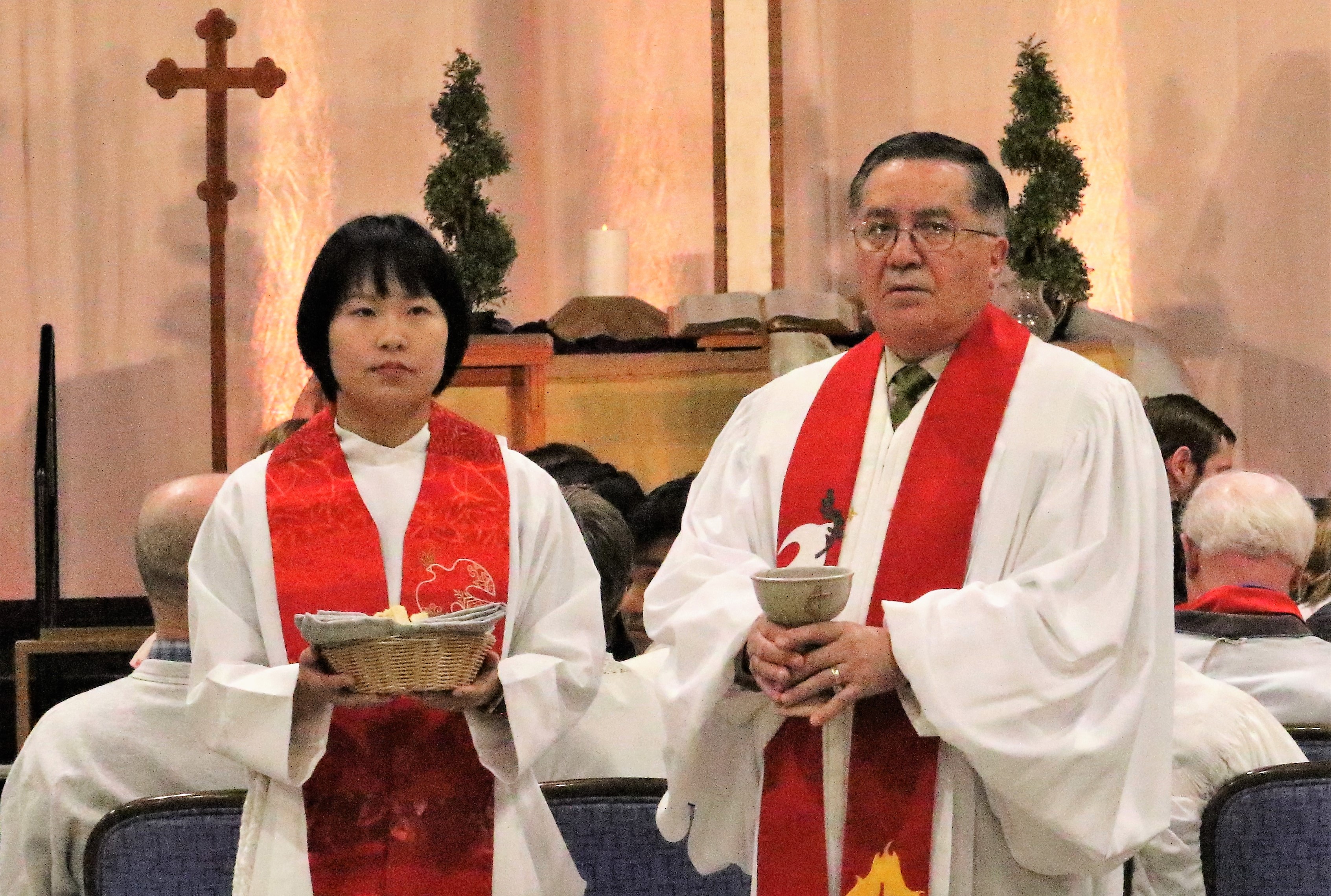 루이스교회리더십센터의 조사에 따르면, 연합감리교회의 35세 미만의 장로목사 수가 사상 최저를 기록했다. 사진은 2019년 일리노이주 샴버그에서 열린 북일리노이 연회 안수 예배에서 새로이 장로목사로 안수를 받은 유란 목사와 은퇴하는 마리오 마이어 목사가 성찬을 분급하기 위해 기다리고 있다. 사진, 김응선 목사, 연합감리교뉴스.