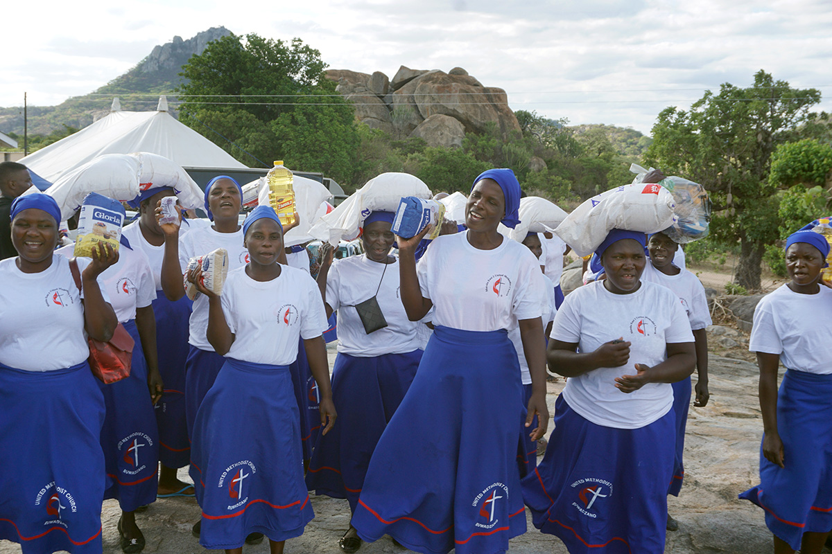 United Methodist women celebrate after receiving food parcels at Bwanya United Methodist Church in Zimbabwe. The early Christmas celebration was hosted by the Mukandi family, who provided lunch and gifts for 250 members from six local churches near Mutoko. Photo by Kudzai Chingwe, UM News.