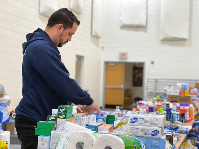 The Rev. Yasmel Reyes sorts through donated goods inside the gymnasium of Madisonville First United Methodist Church in Madisonville, Ky. The church is offering aid to those affected by deadly storms in Hopkins County on Dec. 10. Photo by Brandon Buchanan, courtesy of Madisonville First United Methodist Church.