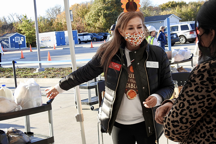 Ligia Urrego greets a woman who has come to The Storehouse of Collin County in Plano, Texas, to receive a free turkey and other food in November. Urrego serves on the board of The Storehouse, a nonprofit that began at Plano’s St. Andrew United Methodist and continues to have its food and clothing distribution operations there. “We’ve been very busy. The need now is bigger than ever,” Urrego said. Photo by Sam Hodges, UM News.