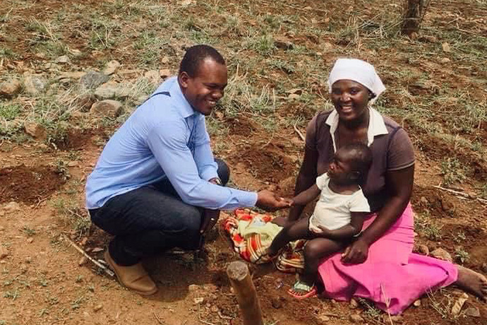 The Rev. César Lodiha Akoka visits with one of the widows he is assisting through his Volunteers in Mission club started at Africa University in Mutare, Zimbabwe. Photo by Chenayi Kumuterera, UM News.