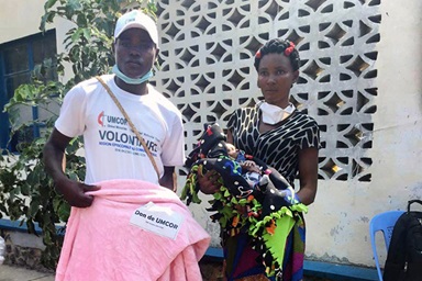 Madame Ortance Tshikonga 38 ans et l'un des volontaires qui l’a aidé à transporter ses vivres et non vivres après la réception. Tshikonga  est veuve et Mère de quatre enfants. Plus de 415 familles constituées de plus de 2 490 personnes expulsées de l’Angola, ont bénéficié de la nourriture et vêtements, une assistance de l’Eglise Méthodiste Unie. Photo du Pasteur Serge Mukendi, UM News. Madame Ortance Tshikonga 38 ans et l'un des volontaires qui l’a aidé à transporter ses vivres et non vivres après la réception. Tshikonga  est veuve et Mère de quatre enfants. Plus de 415 familles constituées de plus de 2 490 personnes expulsées de l’Angola, ont bénéficié de la nourriture et vêtements, une assistance de l’Eglise Méthodiste Unie. Photo du Pasteur Serge Mukendi, UM News.