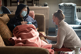 The Rev. Ruth Marsh (right) comforts Angi Rogers, a guest in the day shelter at Trinity United Methodist Church in Idaho Falls, Idaho. Rogers had not been feeling well and Marsh settled her in a Sunday school classroom to get some rest. Photo by Mike DuBose, UM News.