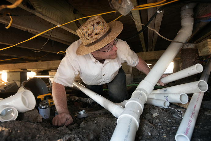 A volunteer from the Amish community in Ohio makes plumbing repairs to a home damaged by natural disasters in Lake Charles. He did not wish to be named. Photo by Mike DuBose, UM News.