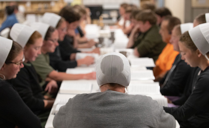 Amish women sing a hymn during a dinner at University United Methodist Church in Lake Charles to celebrate their two-week stint as volunteers helping to repair storm-damaged homes in the area. Photo by Mike DuBose, UM News.