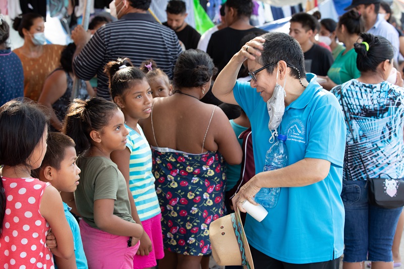 La llegada de inmigrantes a la frontera sur de Tejas es constante y representa el espacio ministerial recurrente donde Cindy se dedica a proveer medicinas, alimento, orientación, información apoyo espiritual y muchas otras cosas que las familias necesitan. LA imagen corresponde a la visita que un equipo de Noticias MU hizo a la frontera entre las ciudades de McAllen (EE.UU.) y Reynosa (México), donde se encontraba un campamento en una plaza pública, donde se albergaban unos/as 6 mil migrantes aproximadamente, a la espera por presentar sus peticiones de asilo. Foto Mike DuBose, Noticias MU. 