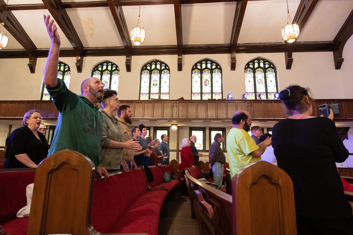 Thomas Clark raises his arm in praise during worship at Magnolia Avenue United Methodist Church. Photo by Mike DuBose, UM News.