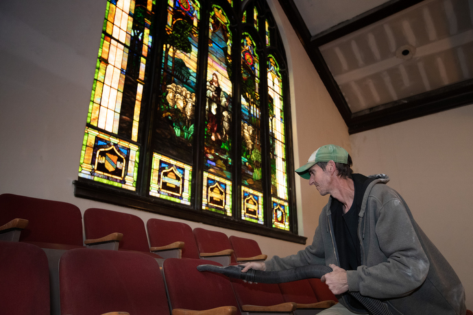 Mike McBee cleans drywall dust from seats in the balcony at Magnolia Avenue United Methodist Church. The 96-year-old church is undergoing extensive renovations and repairs. Photo by Mike DuBose, UM News.