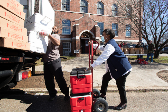 Devin Oliver (left) of CAC Transit delivers food for the free community meals and food pantry offered by Magnolia Avenue United Methodist Church. Helping move the supplies into the church is Cynthia Finch, president of New Direction Healthcare Solutions, a nonprofit organization that provides community-based healthcare and education. Photo by Mike DuBose, UM News.