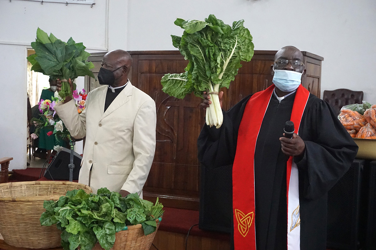 The Revs. Daniel Mutidzawanda (right) and Zebediah Marewangepo pray over the first portion of the harvest, which is given to God, at Chisipiti United Methodist Church in Zimbabwe. Photo by Kudzai Chingwe, UM News.