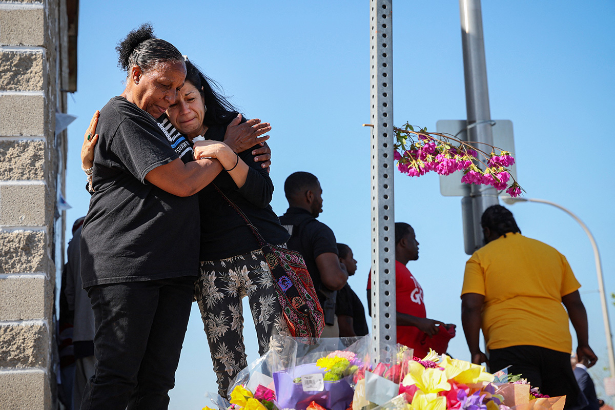 Mulheres olham para um memorial das vítimas perto da cena de um tiroteio em um supermercado Tops em Buffalo, Nova York. Após o que as autoridades rapidamente identificaram como um ataque racista, os Metodistas Unidos estão respondendo com orações, aconselhamento e condenações ao ódio. Foto de Brendan McDermid, Reuters.