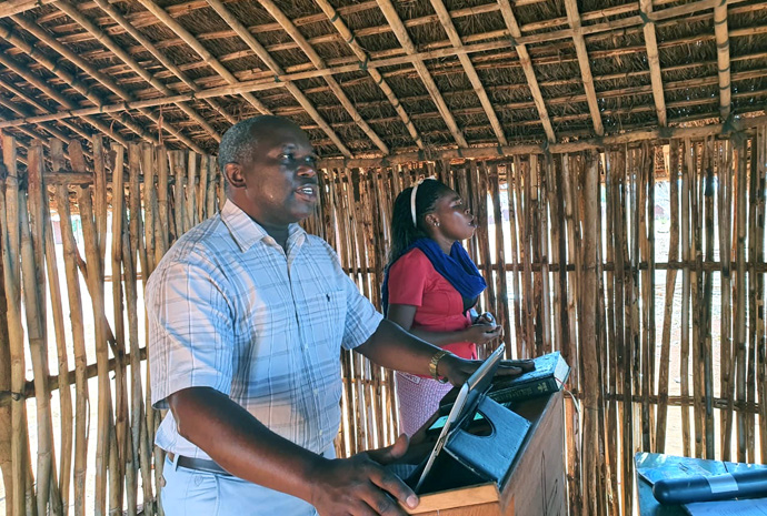 Arlindo Jossias Sambo preaches in Ninga at a new United Methodist church that he started in 2021, while Celine Miguel translates. Sambo graduated from Africa University in 2008 with a degree in economics and has worked with the National Roads Administration — Public Institute (ANE-IP) since graduating. An enthusiastic volunteer for the church, he helped to establish two United Methodist congregations. File photo by Michaque Ali. 