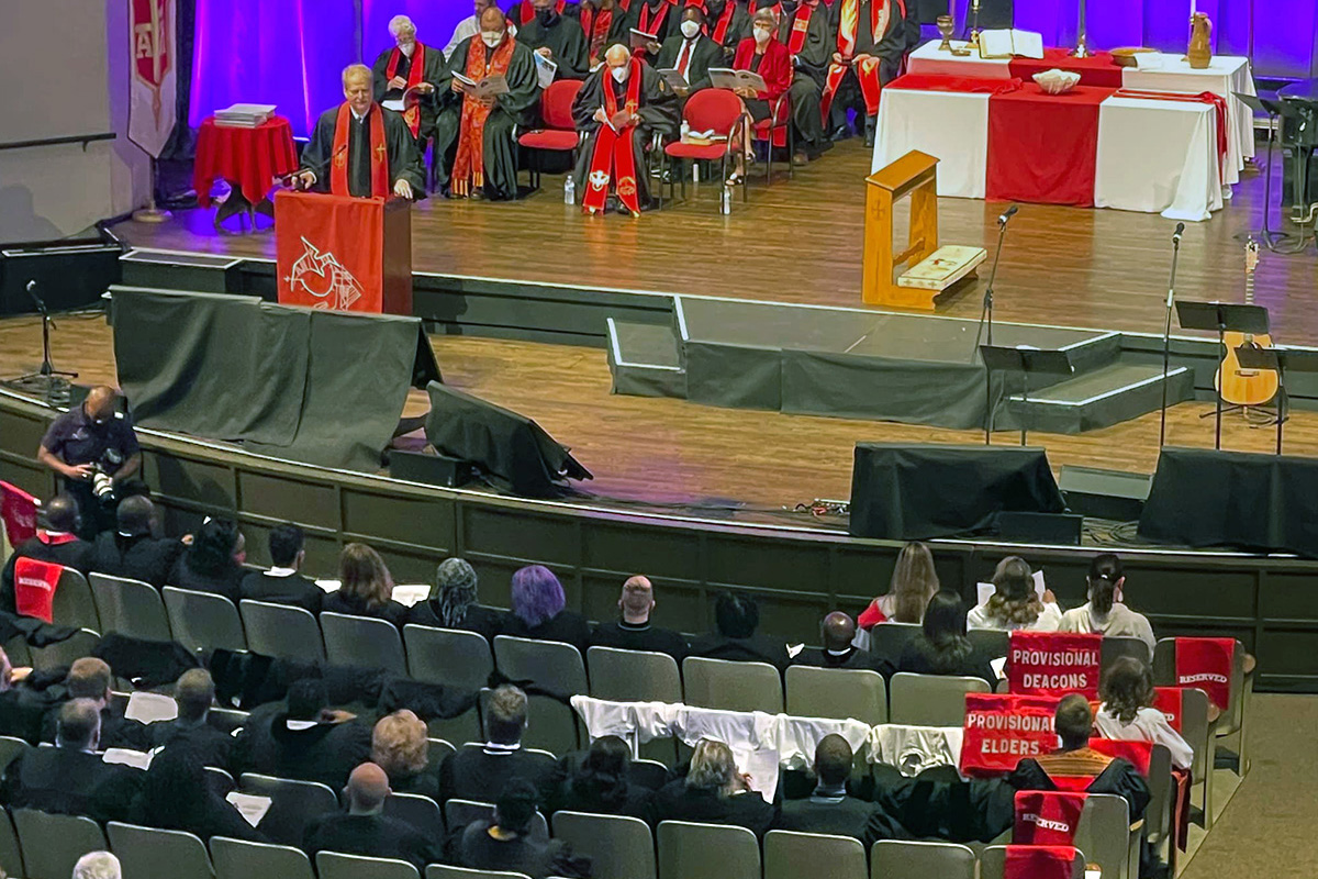 Cadeiras drapeadas simbolizam que os candidatos da Conferência da Flórida para membros provisórios - um passo importante para a ordenação como presbítero ou diácono - não foram aprovados pela sessão do clero da conferência. A decisão controversa, tomada durante a reunião da conferência em Lakeland, Flórida, ilustrou a divisão denominacional sobre a inclusão LGBTQ. A decisão também alterou o serviço de conclusão de 11 de junho, onde os 16 deveriam ser comissionados. Foto de Esther Rodriguez via Facebook.