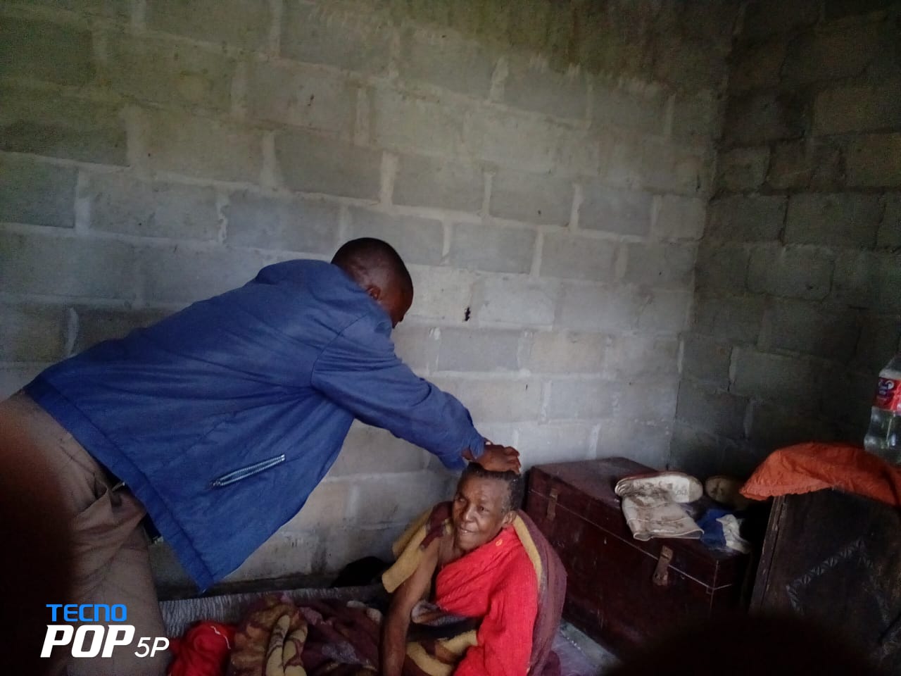 Rev. Calton Ngale implorando a bencao sobre a beneficiaria da casa, a ancia Victoria Jamisse. Beira, foto de Eurico Gustavo