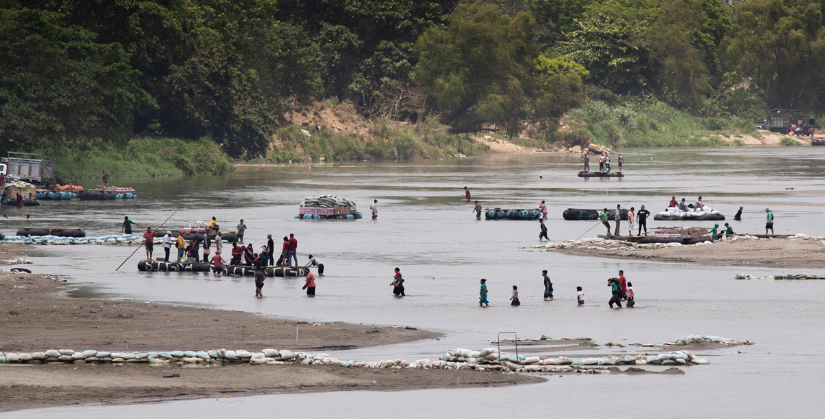 People wade or ride rafts made from inner tubes across the Suchiate River, which forms part of the border between Guatemala and Mexico, near Ciudad Hidalgo, Mexico. The busy, informal crossing is used by migrants as well as by people hauling commercial cargo in both directions. A ride across on one of the inner tube rafts usually costs between 10 and 20 Guatemalan quetzals, roughly $1.25-$2.50 U.S.