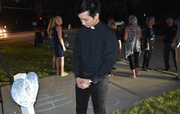 El Rev. Jake Cho quien se mudó a Highland Park hace dos semanas para su nombramiento en la Iglesia Metodista Unida Galilea, ora por las víctimas del tiroteo, cuyos nombres están en siete cruces fuera de la Iglesia Presbiterianas Hightland Park. Foto cortesía de la Conferencia Anual del Norte de Illinois.