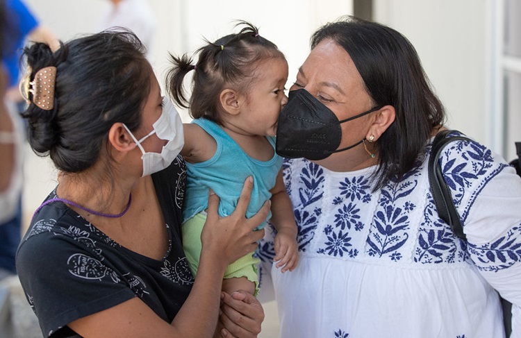 La Obispa Raquel Balbuena Osorio (derecha) de la Iglesia Metodista en México recibe un beso de Zoe, de 14 meses, durante una visita al albergue para migrantes Hospitalidad y Solidaridad en Tapachula. Foto de Mike DuBose, Noticias MU.