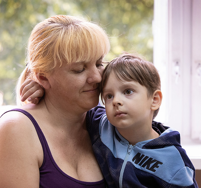 Oksana holds her son, Constantine, in the room they share at the Onokivtsi Secondary School near Uzhhorod, Ukraine. The family fled Kharkiv in northeast Ukraine after Russian forces attacked the city. Photo by Mike DuBose, UM News.
