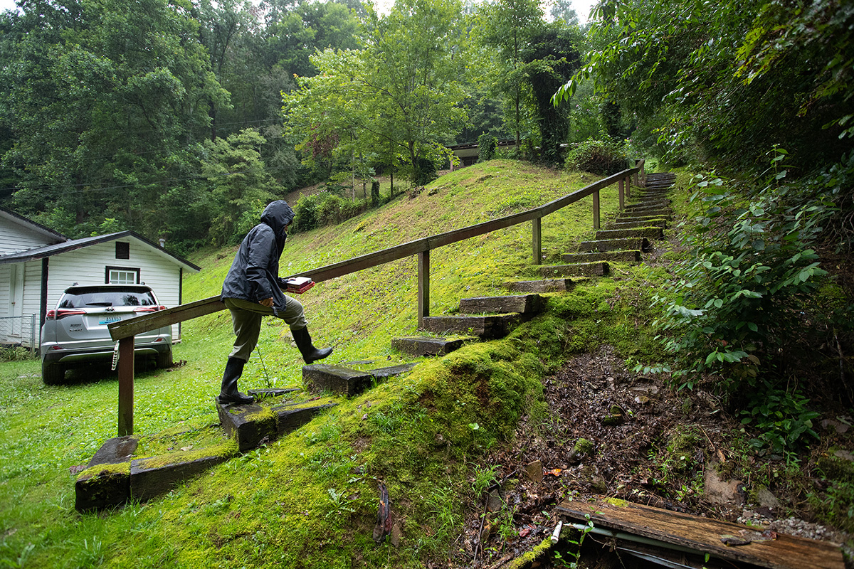 Volunteer Lisa Cox climbs the stairs carrying relief supplies at Marjorie Sexton’s home in Pippa Passes, Ky. Sexton had been without electricity since massive flooding caused power outages across the area. Cox is worship leader at Hindman (Ky.) United Methodist Church. 